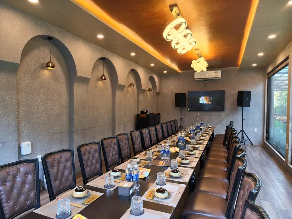 Cụng Beer VIP room: long table with leather chairs, arched walls, TV and karaoke speakers